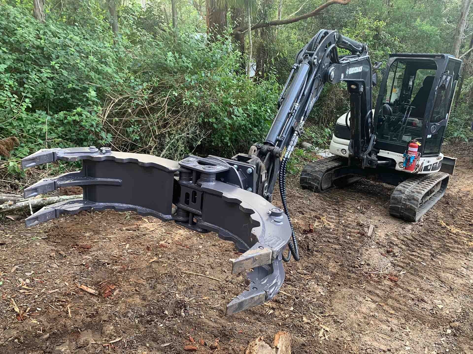 Excavator With Grapple Attachment in a Wooded Area — All Tree Solutions In HOLGATE, NSW