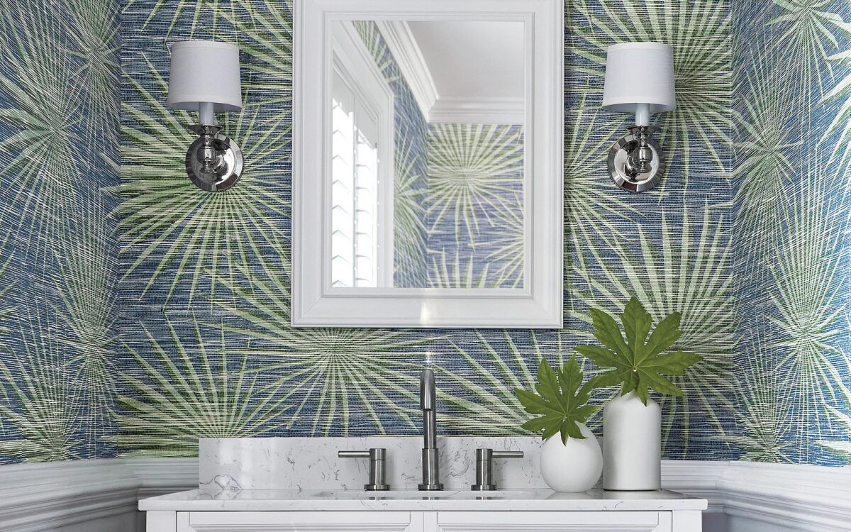 Bathroom vanity with mirrored cabinet, blue leaf-pattern wallpaper, wall sconces, and white sink