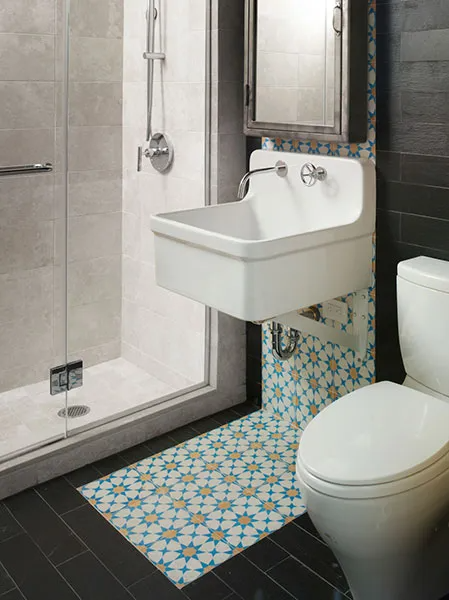 Compact tiled bathroom with a wall-mounted sink, shower, and toilet in black, white, and mosaic accents