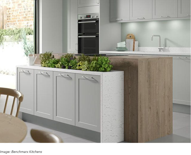 Modern kitchen with gray cabinets, wood island, built-in oven, and a potted herb planter center piece