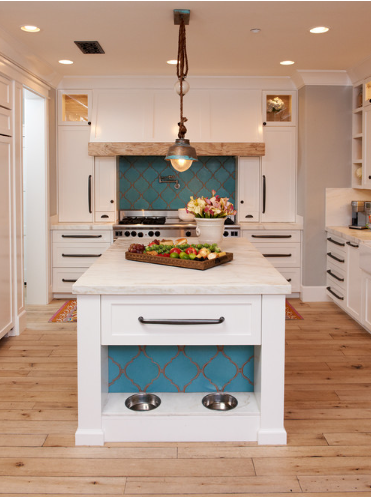 Bright white kitchen with a central island, wood floors, and blue tile accents