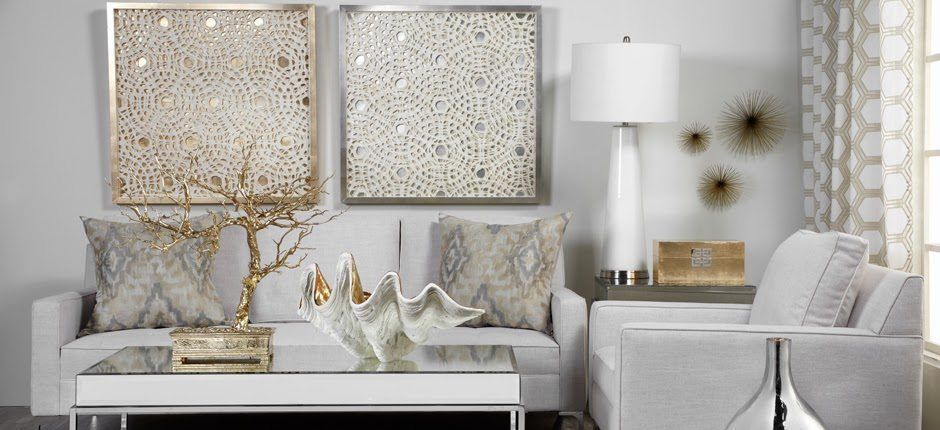 Elegant silver and gold living room with mirrored art, white sofa, lamp, and decorative accents