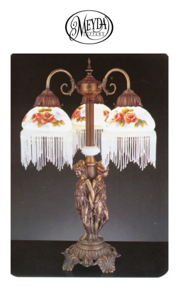 Ornate vintage table lamp with two frosted floral shades and bronze base on a black background