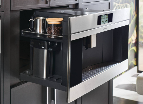 Built-in kitchen drawer with a coffee maker and mugs stored inside