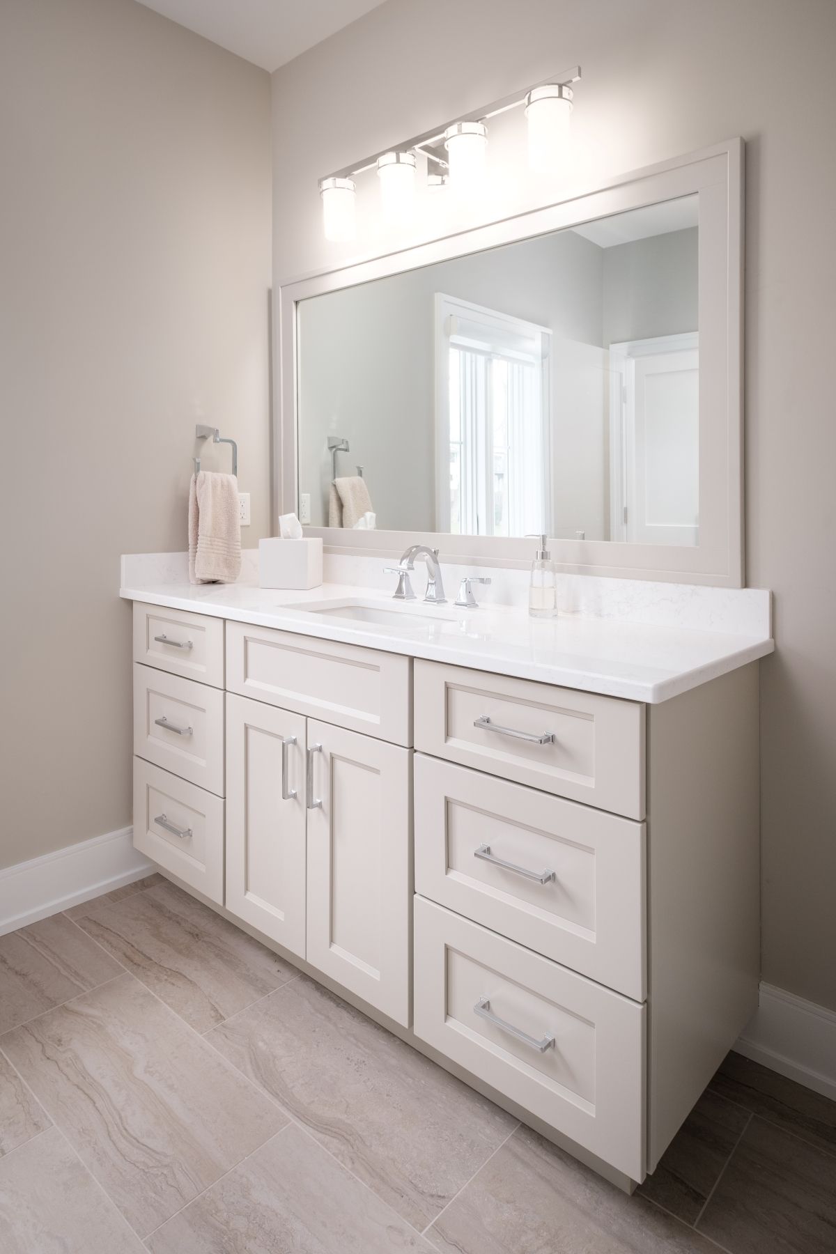 White bathroom vanity with dual sinks, large mirror, and light wood floor in a bright modern room