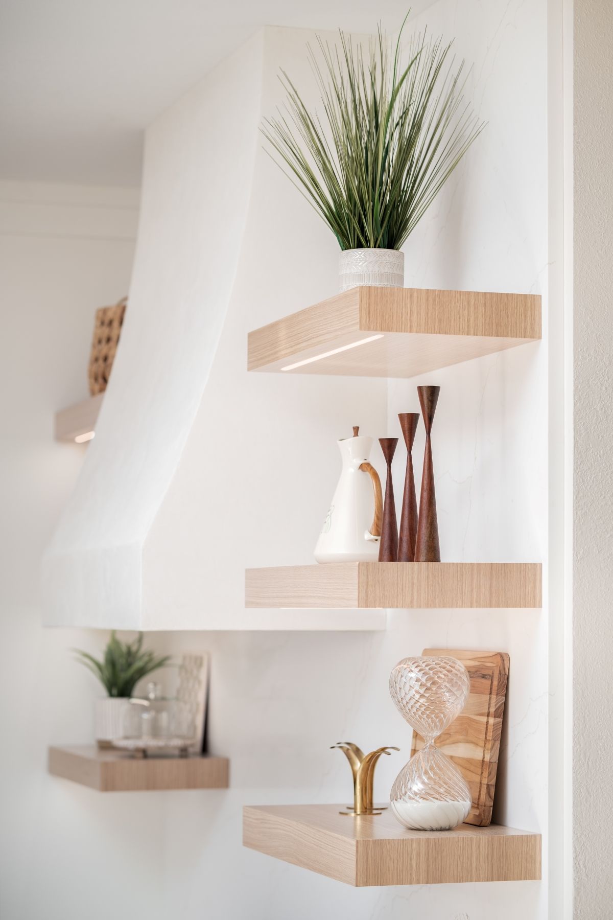 Minimalist wall shelves with potted plants and decorative vases in a bright room