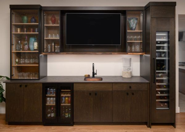 Dark wood entertainment center with TV, shelves, cabinets, and countertop storage