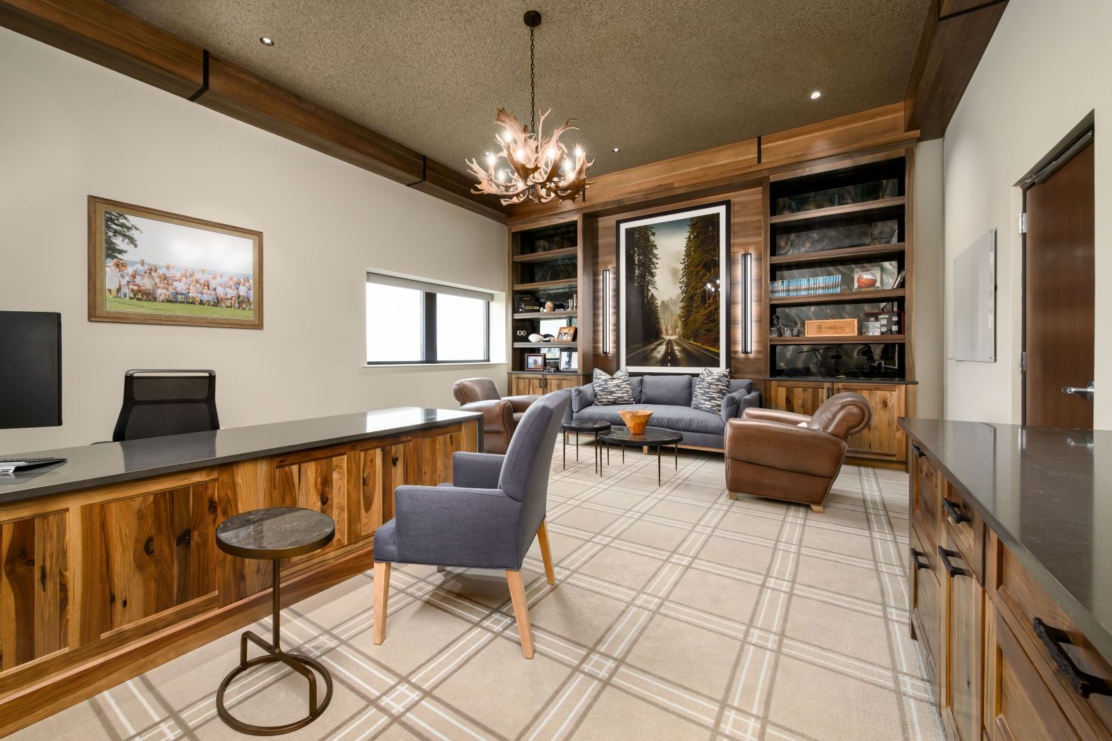 Modern living room with sectional sofa, fireplace, bookshelves, and large windows