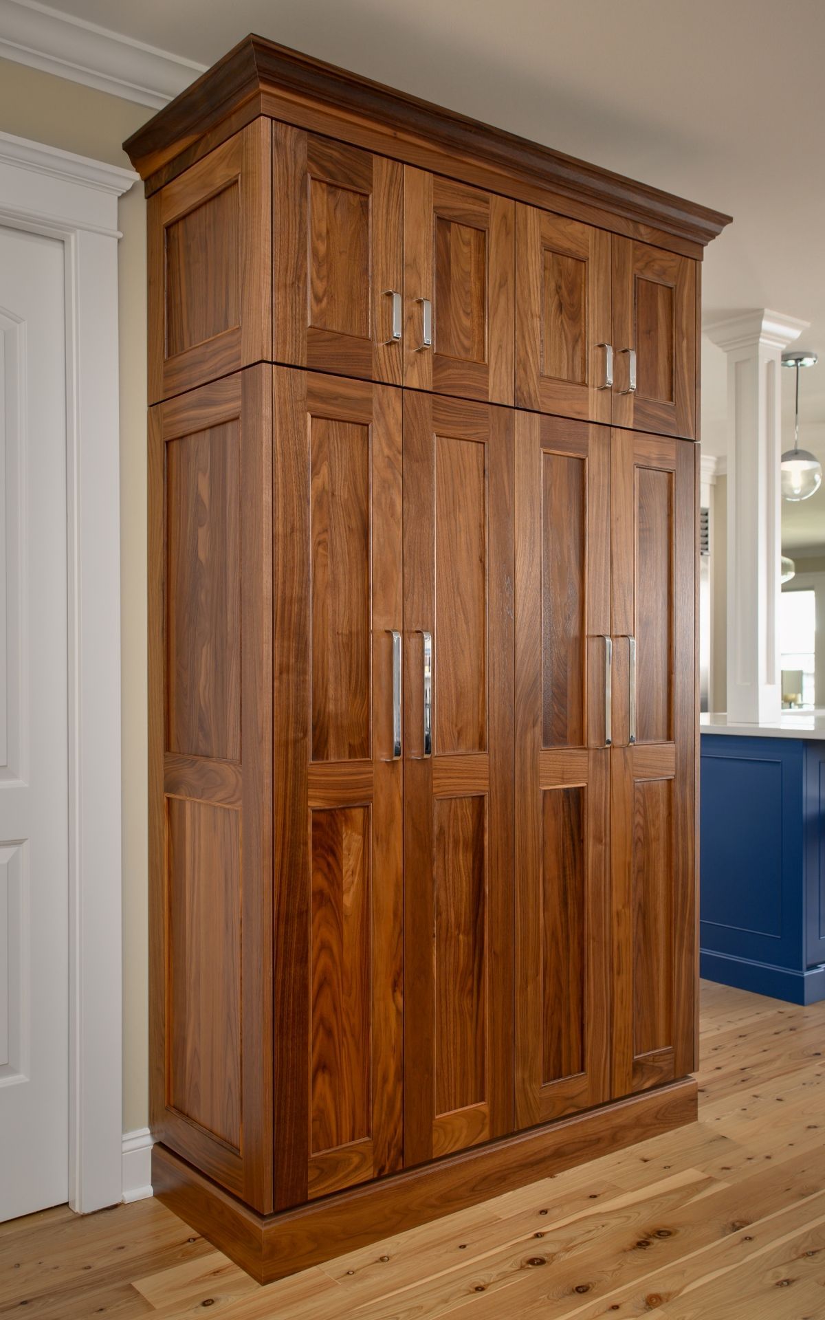 Tall wooden wardrobe cabinet with double doors in a bright room