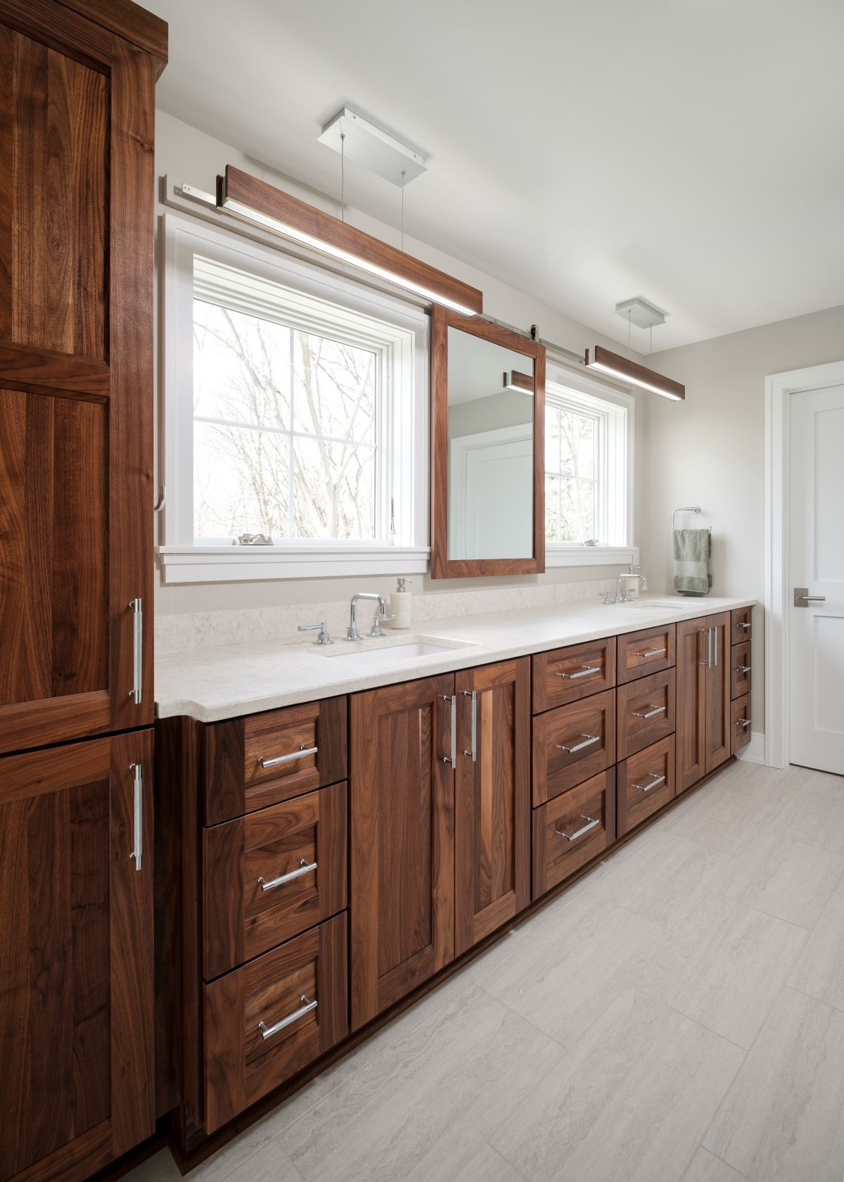 Modern bathroom vanity with dark wood cabinets, double sinks, large mirror, and white countertop