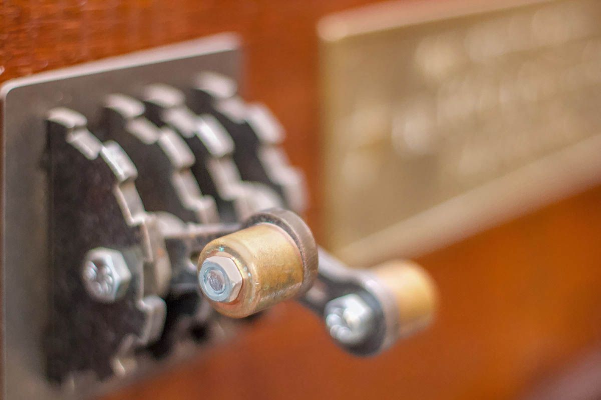 Close-up of a vintage combination lock on a wooden suitcase, with metal dials and a blurred background