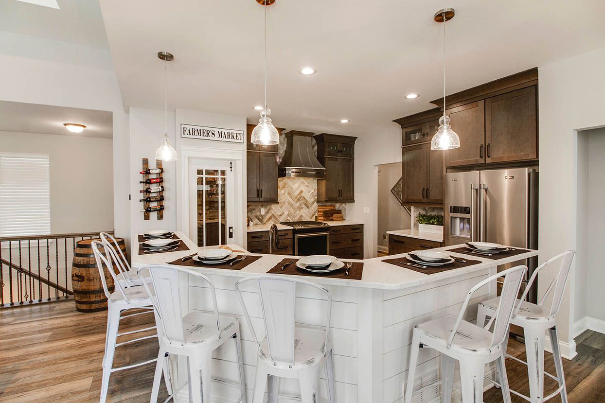 Modern kitchen with white dining table, white chairs, and stainless steel appliances
