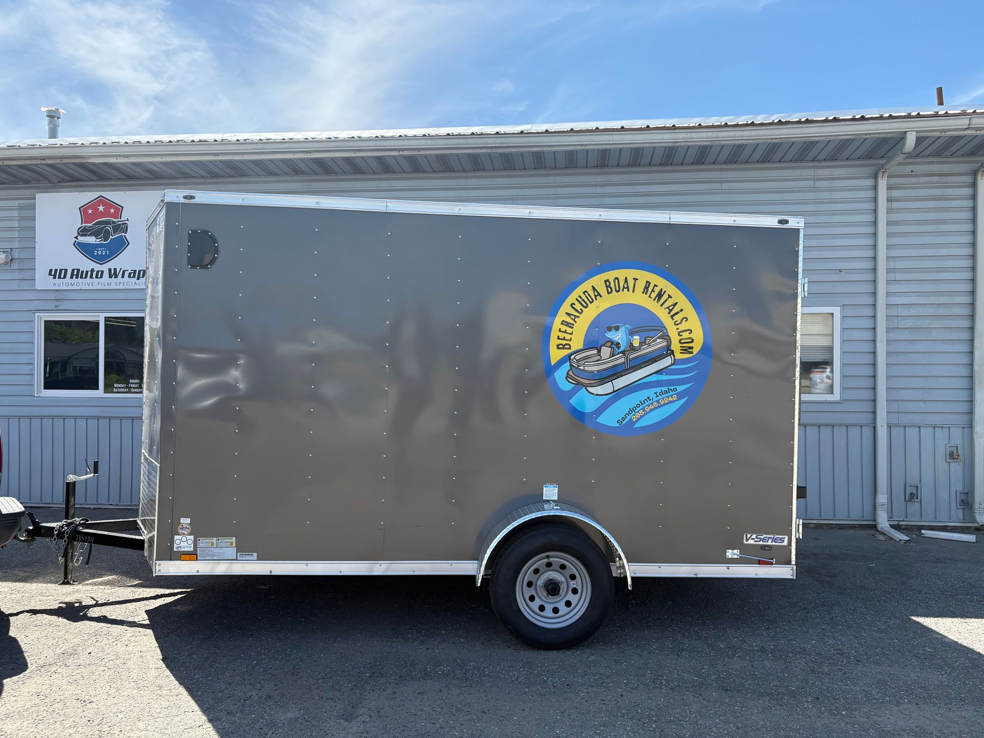 Gray enclosed trailer with a logo for 