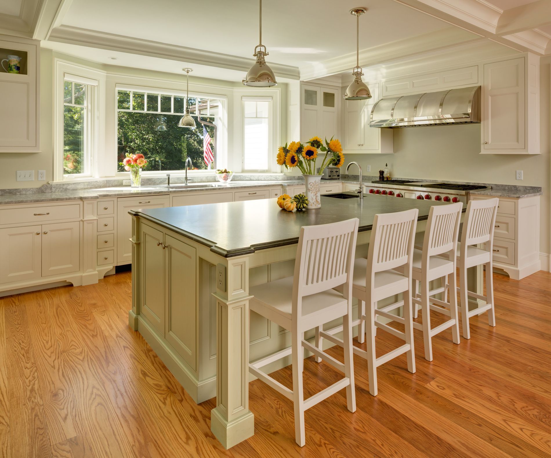 A kitchen with white cabinets , stainless steel appliances , a sink , and a window.