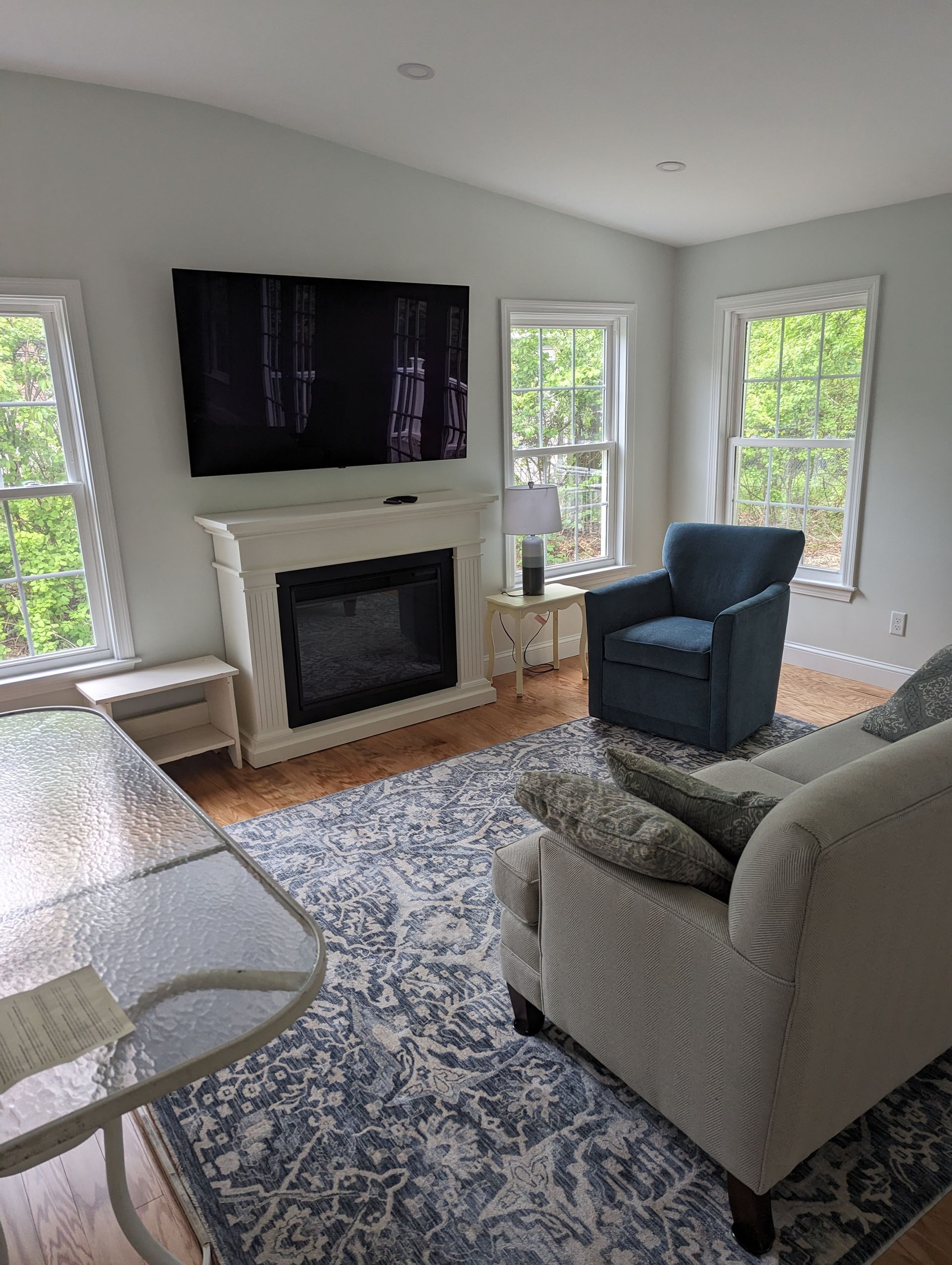 A living room with a fireplace , couch , chair and television.