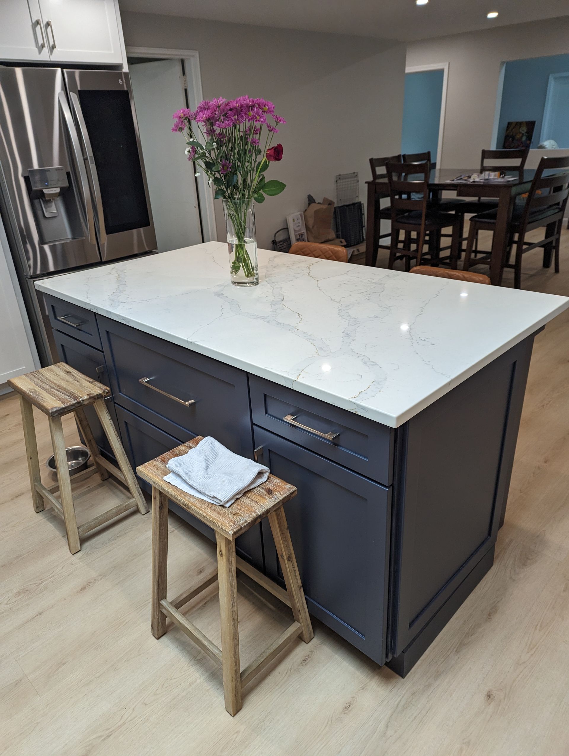A kitchen island with a vase of flowers on top of it.