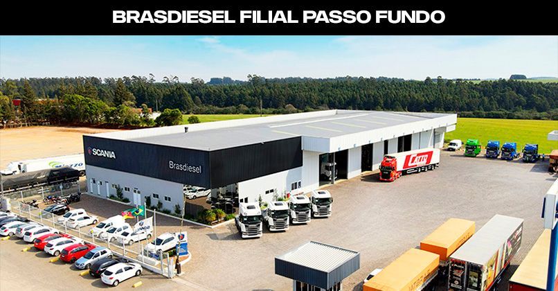 Vista aérea da concessionária Brasdiesel Scania em Passo Fundo, com caminhões e carros estacionados em um pátio externo.