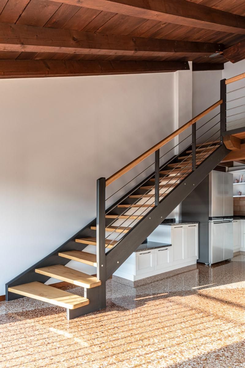 Una scala in legno che porta al secondo piano di una casa.