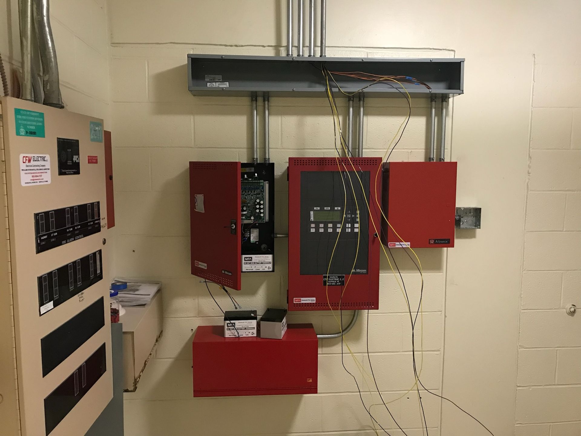 Technician inspecting a commercial fire alarm control panel
