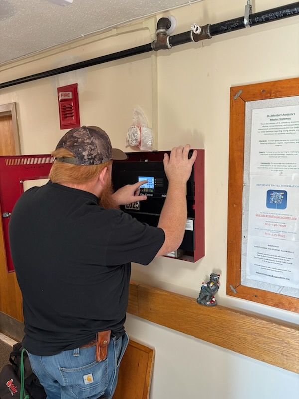 Technician inspecting a commercial fire alarm control panel