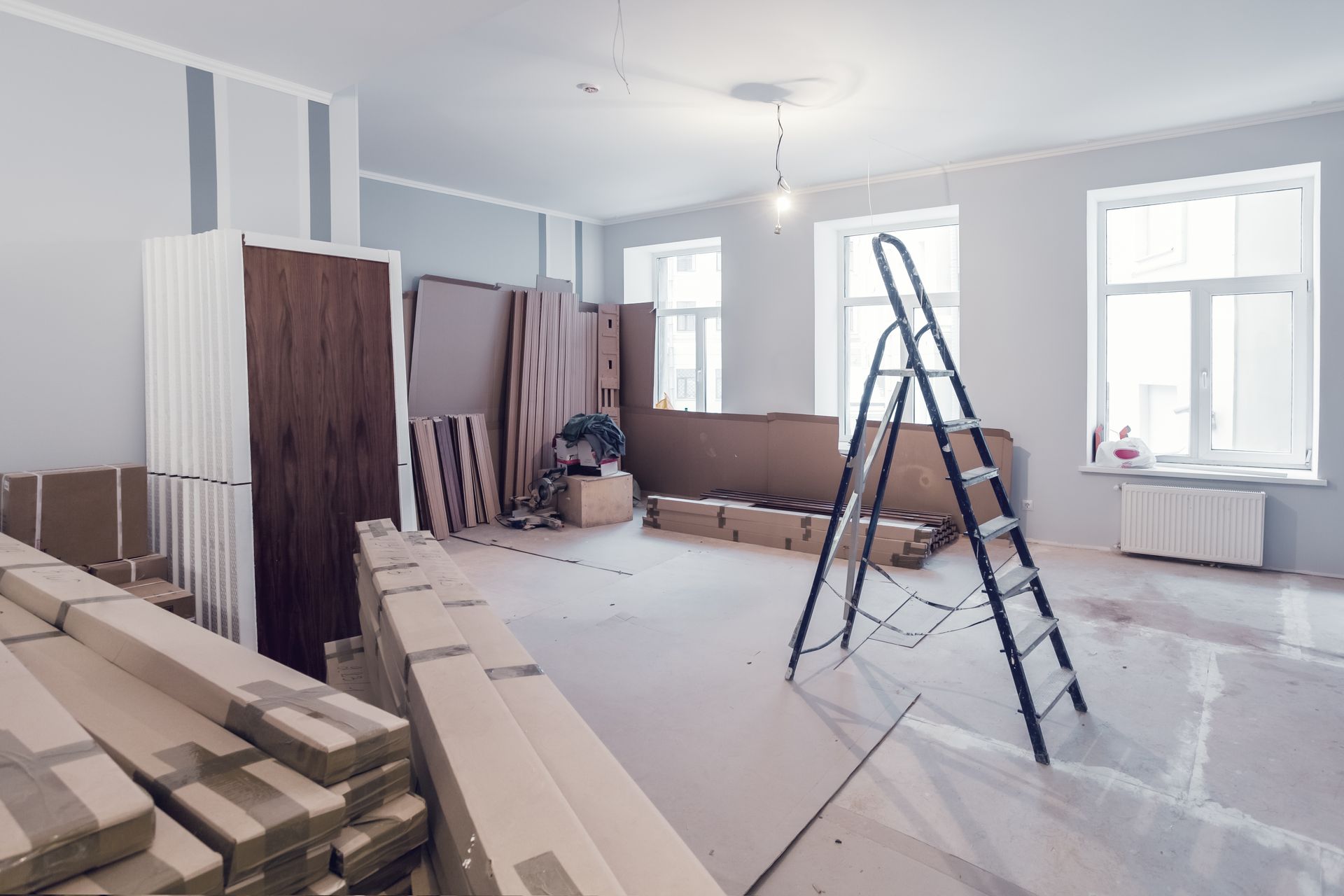 Room under renovation; construction materials and ladder inside.