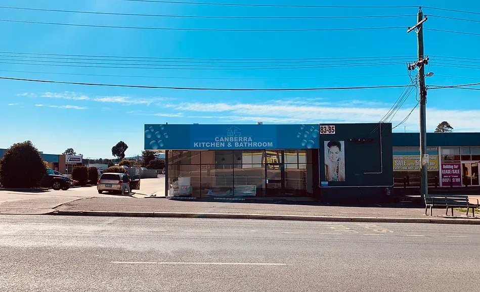 A Building with A Blue Awning Is Sitting on The Side of A Road — Canberra Kitchen & Bathroom in Fyshwick, ACT