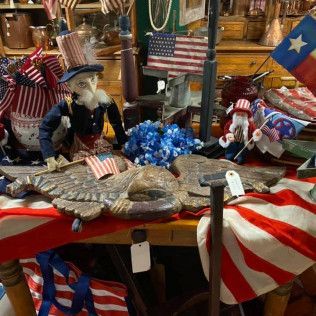 Patriotic tabletop display with eagle centerpiece, Uncle Sam figurines, and U.S. flags in red, white, and blue