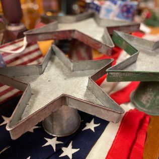 Metal star-shaped cookie cutters on a red, white, and blue American flag cloth