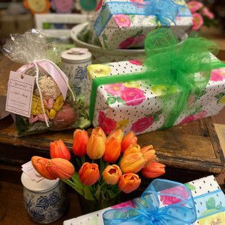 Colorful wrapped gifts with tulips and floral decor arranged on a rustic table
