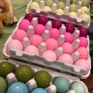 Assorted pastel-colored eggs arranged in open cartons at a market stall