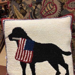 Black dog silhouette pillow with an American flag-patterned bandana on a patterned rug