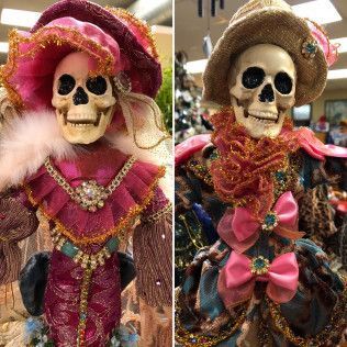 Two decorated skeleton dolls in pink and multicolored costumes and hats