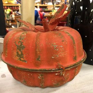 Orange pumpkin-shaped decorative container with a lid on a table