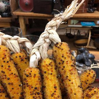 Orange prickly cactus-like sculpture with woven rope top, shown indoors on a shelf.