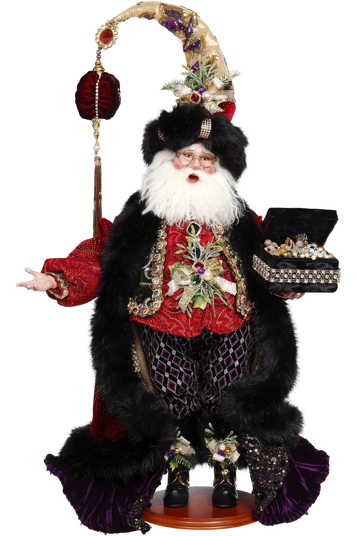 Santa figurine in black and red suit holding an open box of chocolates