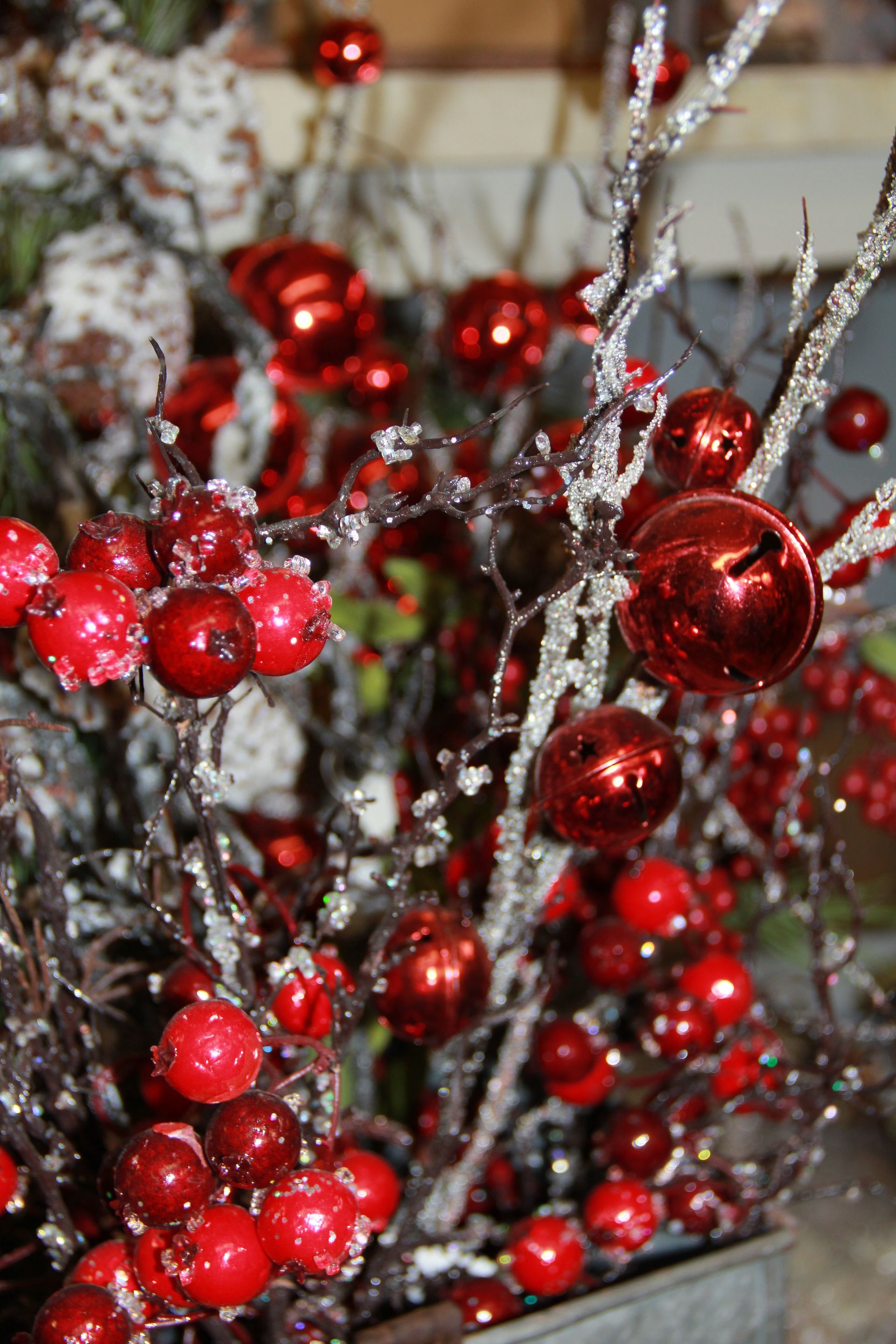 Red berry branches with silver tinsel and shiny red ornaments in a festive arrangement