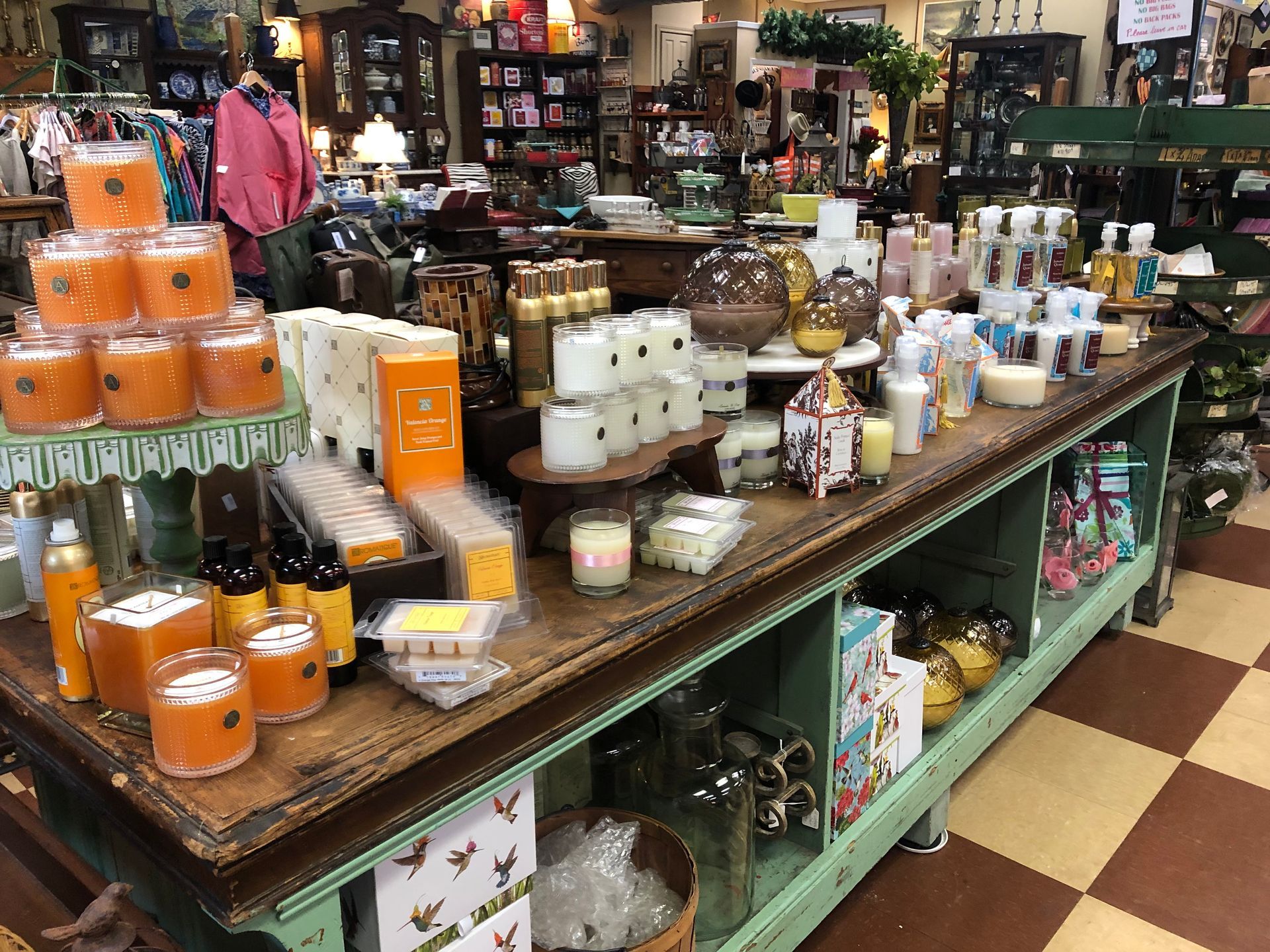 Gift shop display of candles, soaps, and home decor on wooden tables and shelves