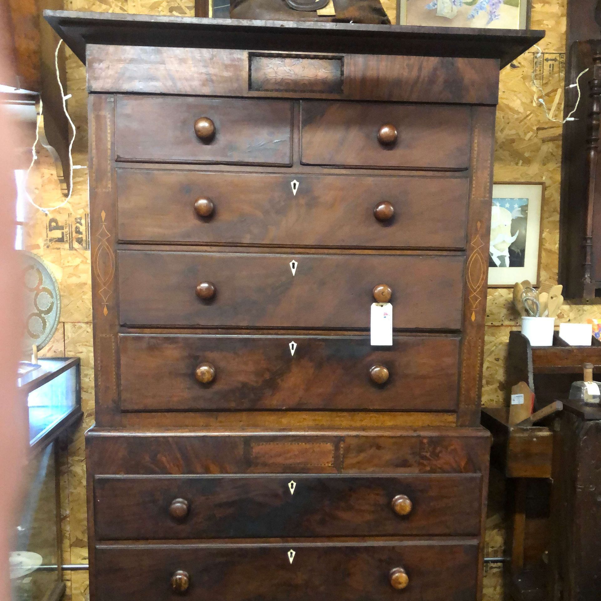 Antique dark wooden chest of drawers with brass knobs in a shop display