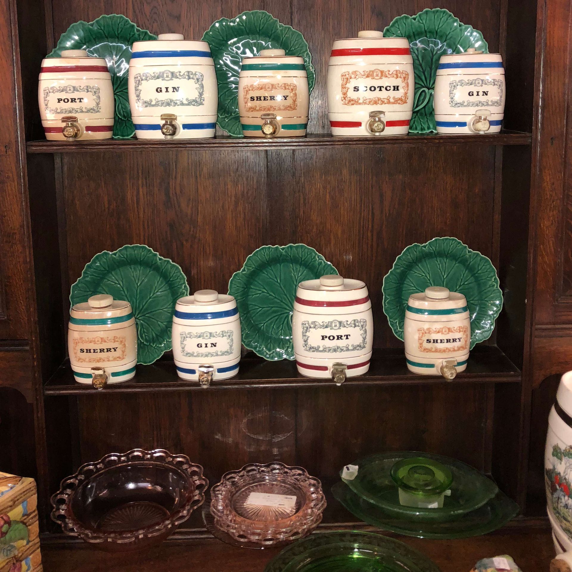 Wooden shelf displaying vintage ceramic jars and dishes with green and blue accents