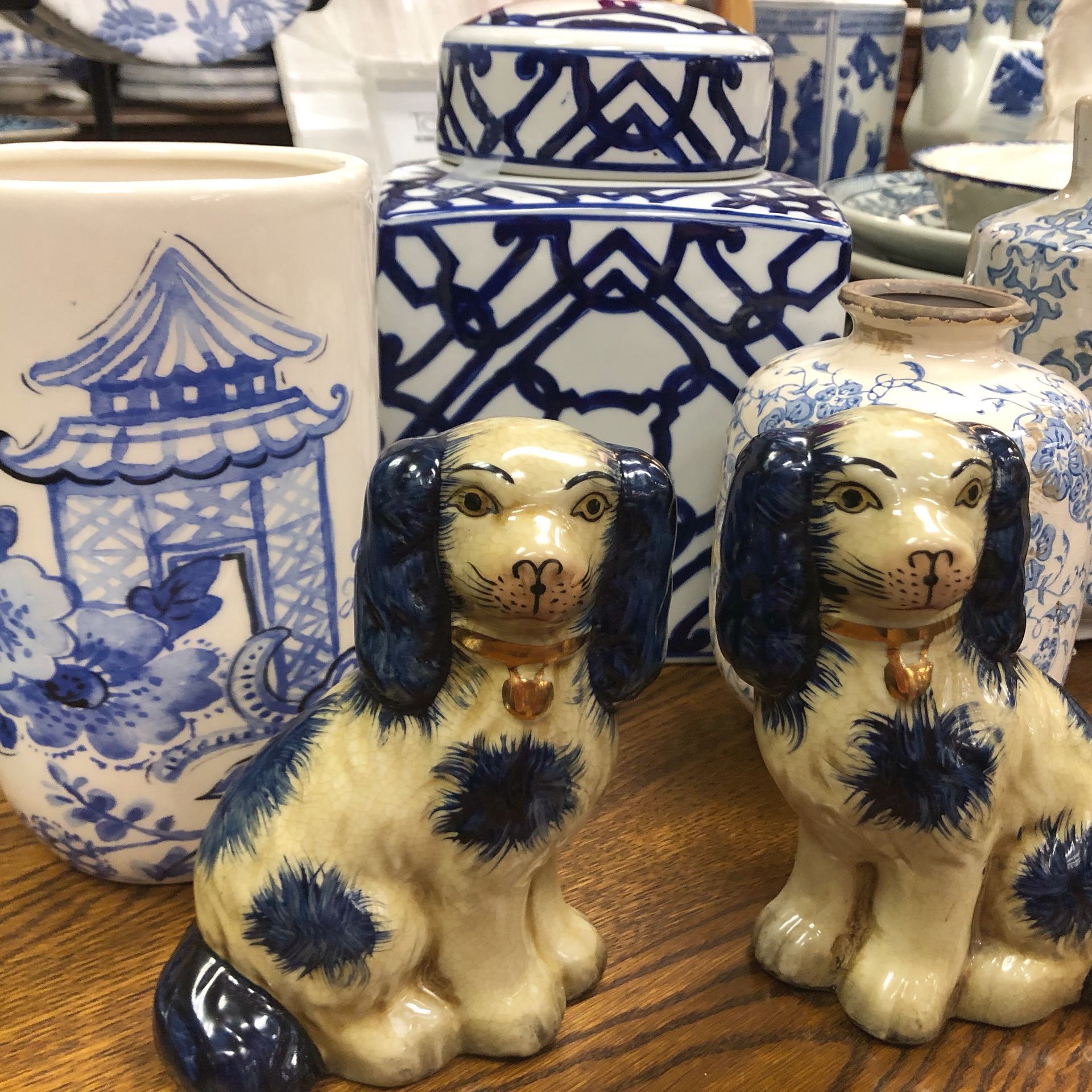 Blue-and-white ceramics with two small dog figurines in front.