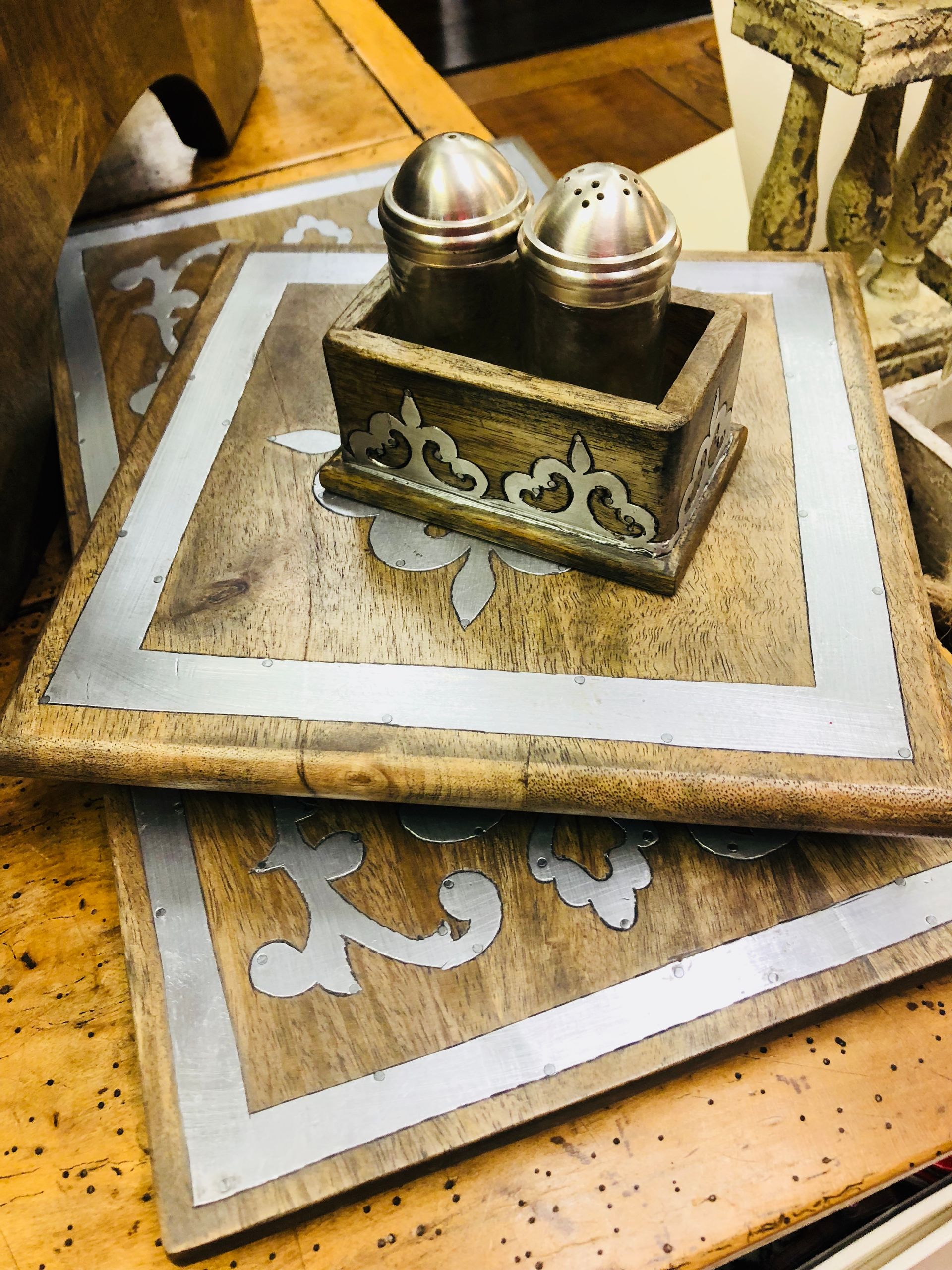 Decorative Islamic-style prayer items on patterned mats, with two silver dome-topped objects in a tray