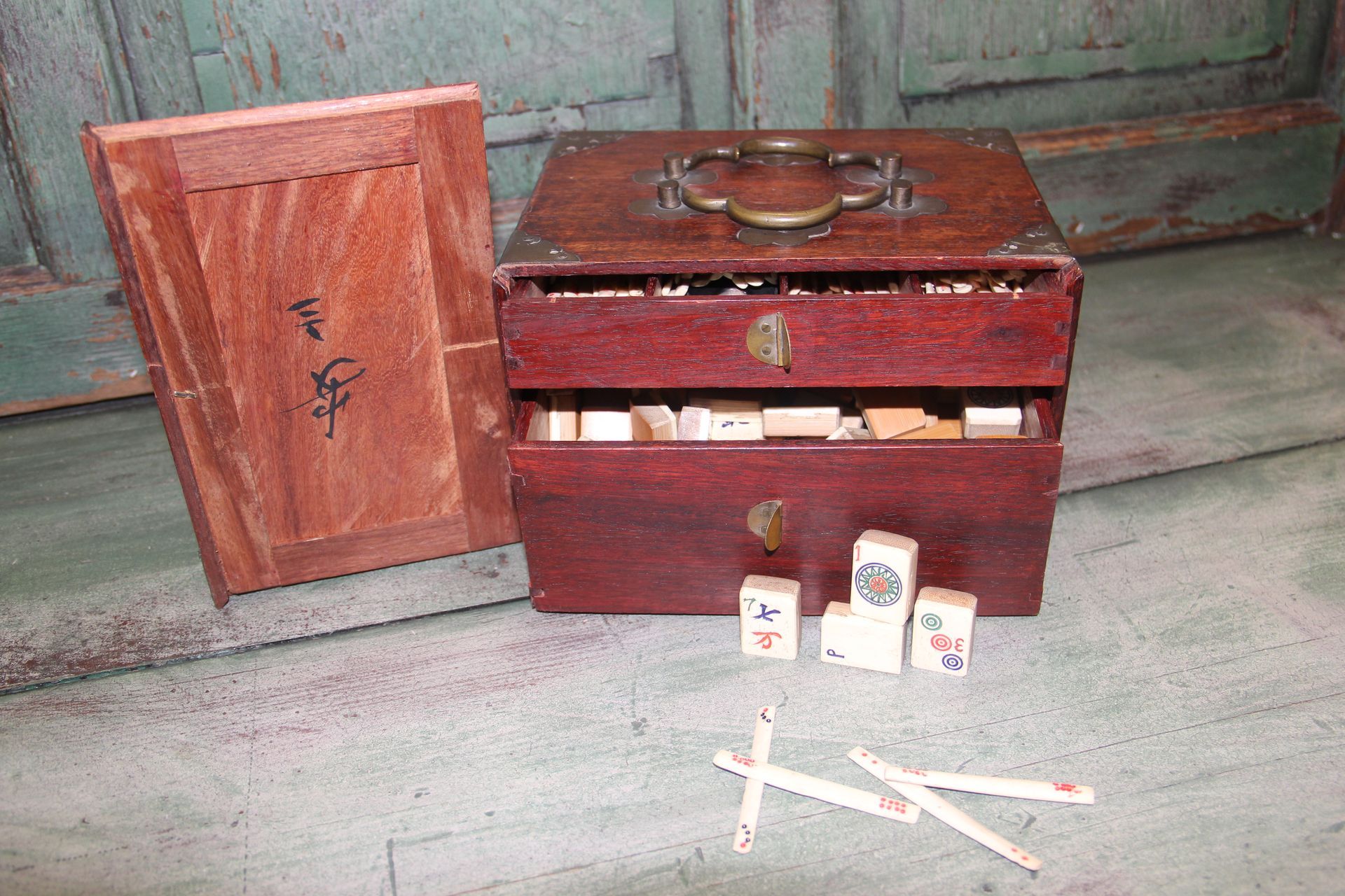 Wooden medical box with bottles and syringes on a weathered floor, lid propped open