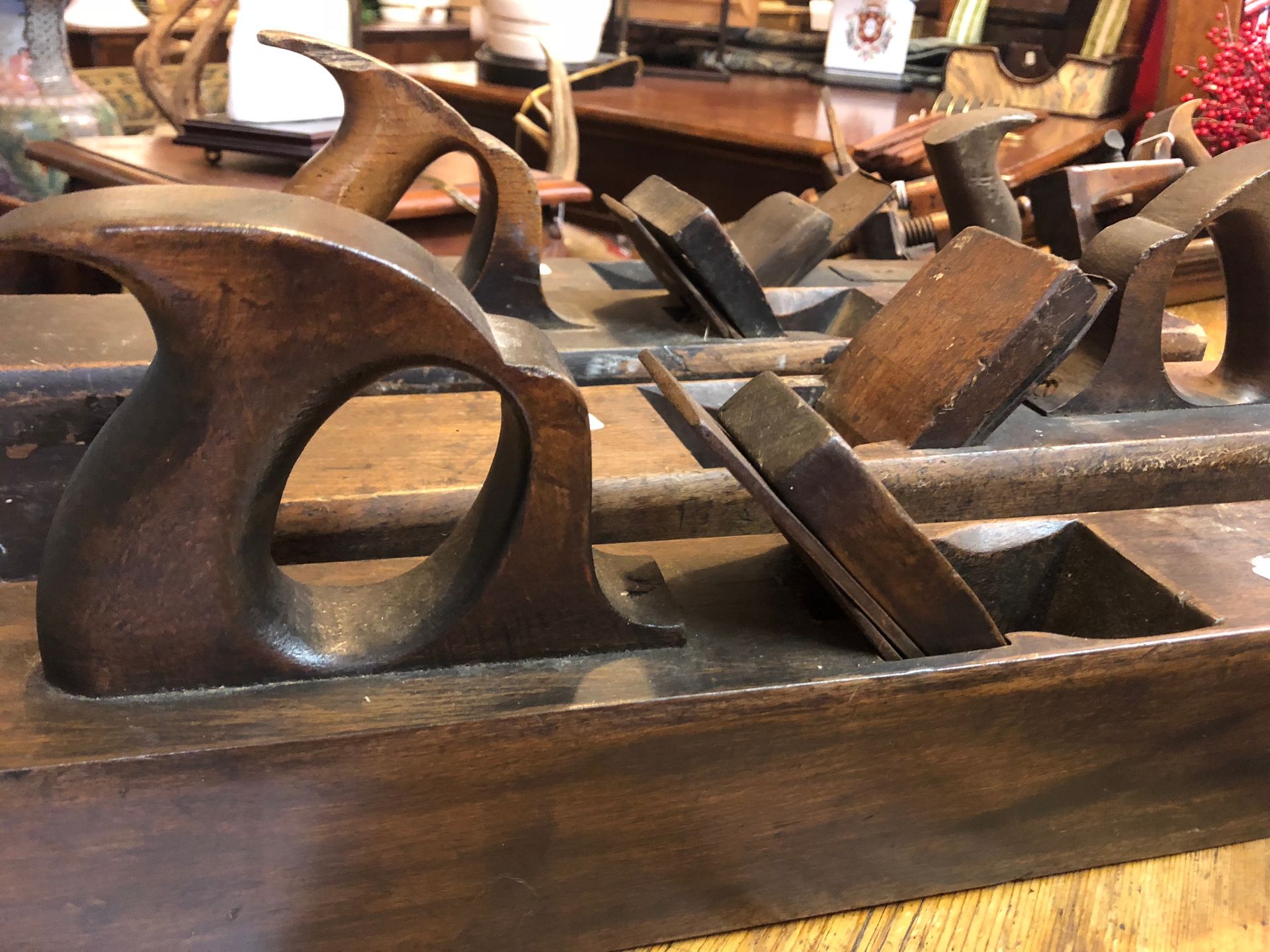 Close-up of antique wooden hand planes arranged on a display shelf