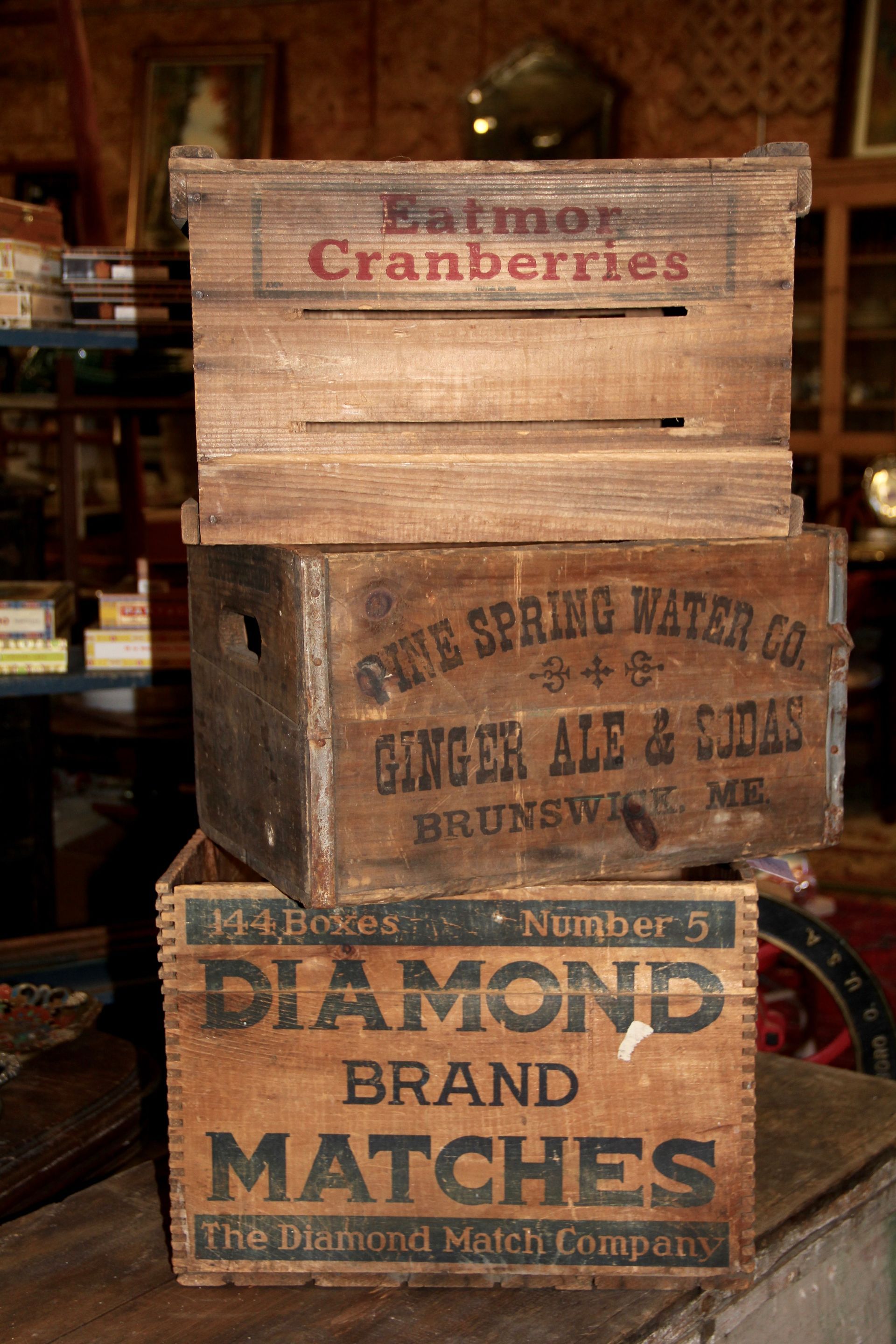 Stacked vintage wooden crates and a Diamond Brand Matches box in a rustic shop display.