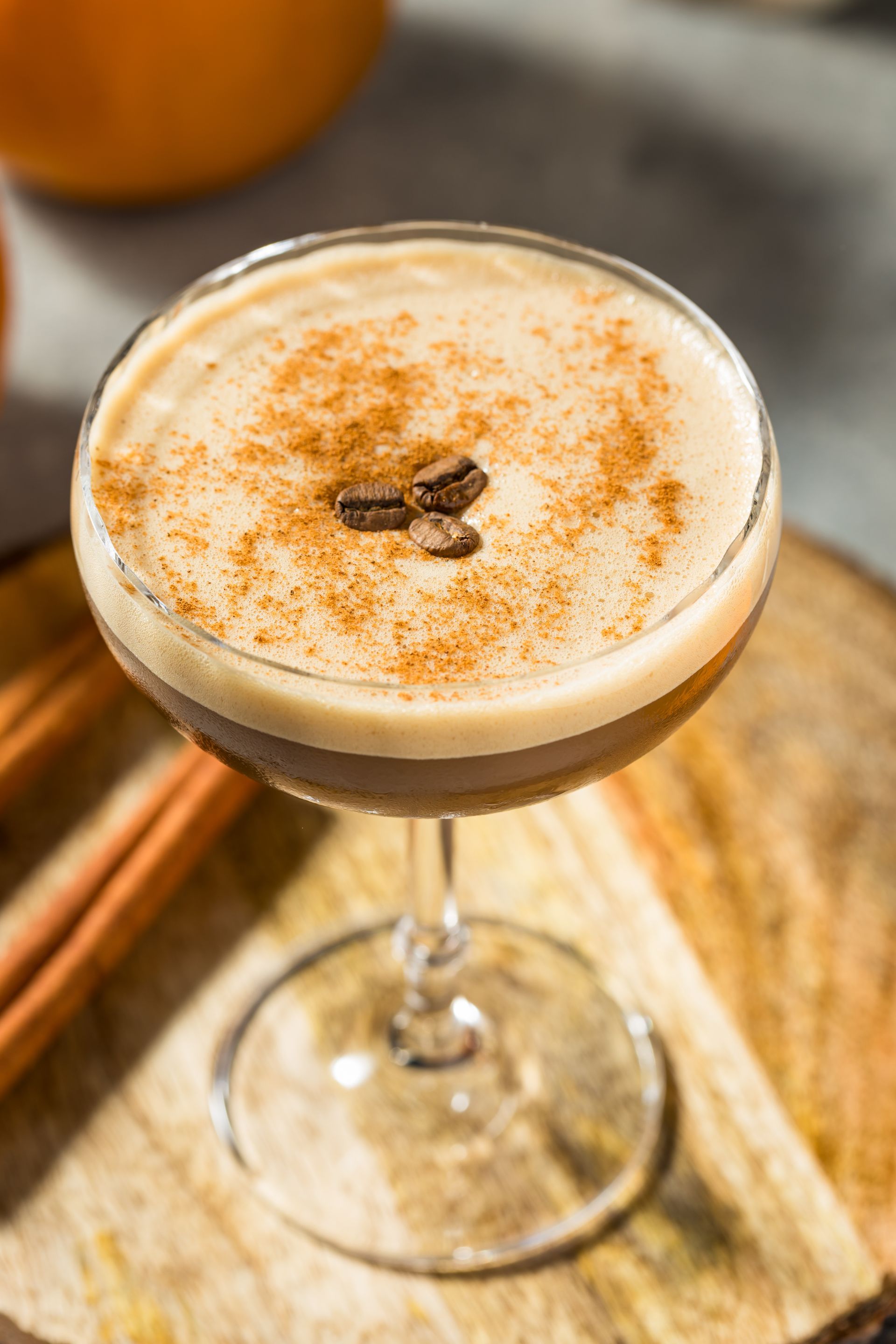 A close up of a martini in a glass on a wooden table.