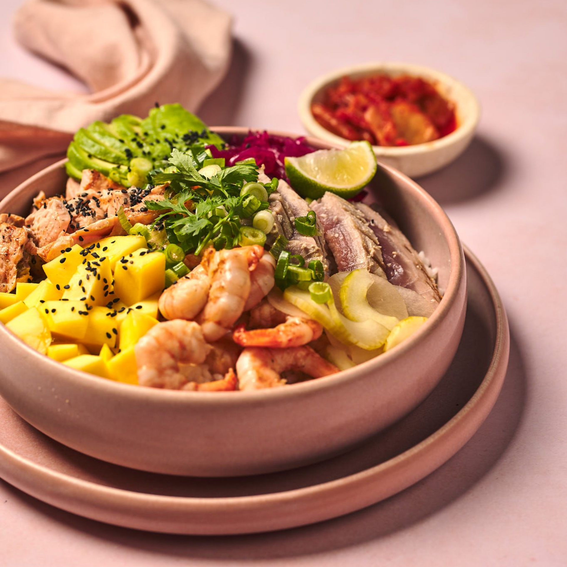 Three plates of food are sitting on a wooden table next to a glass of beer.