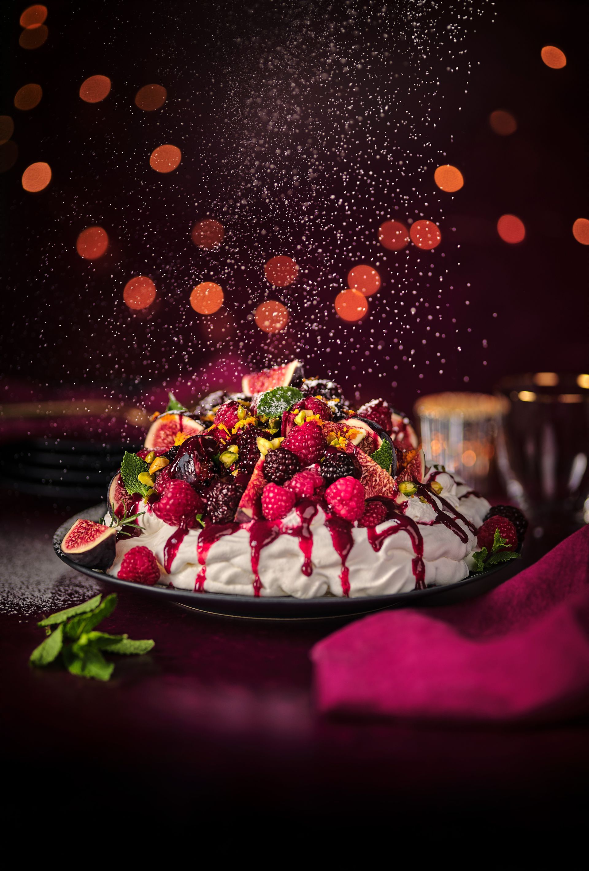 A plate of food with berries and whipped cream on a table.
