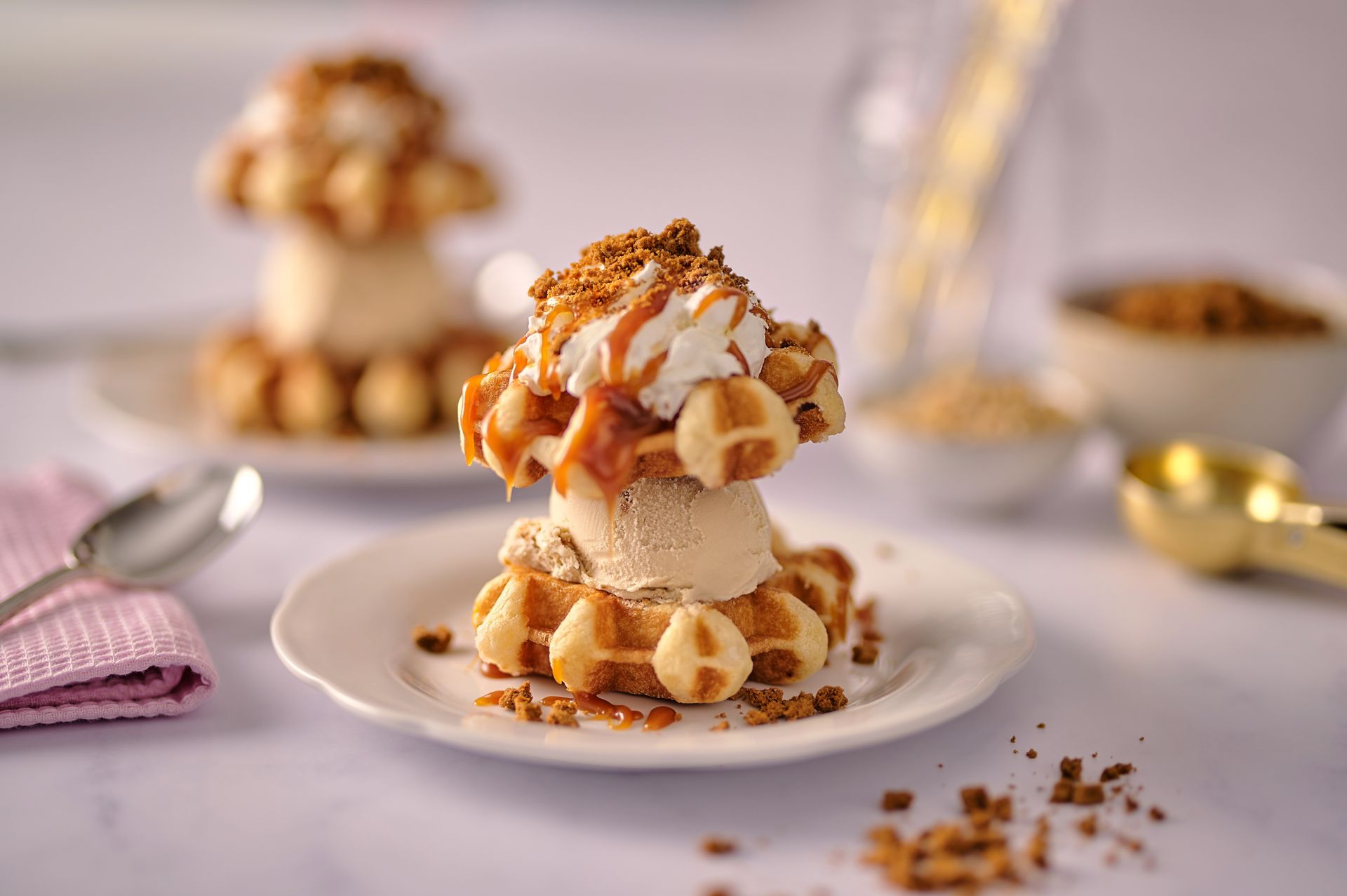 A waffle with ice cream on top of it on a plate.