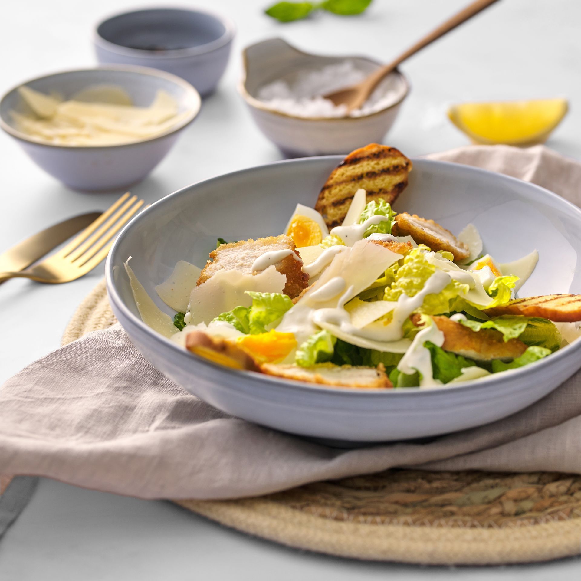 A salad in a bowl on a table with a fork