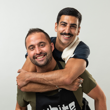 A man with a mustache is carrying another man on his back